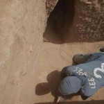 Mohammed carefully cleaning remains of a flood deposit in the upper filling of the shaft.